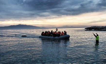 Refugees and migrants on an inflatable boat arrive in Greece.