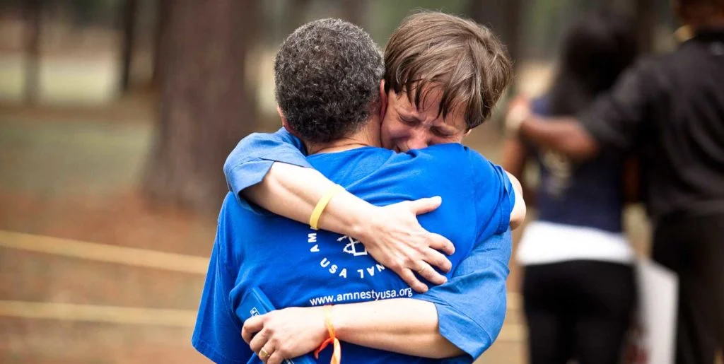 Two people hug at a vigil in Jackson