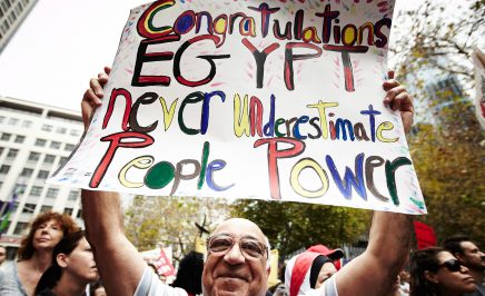 A man holding a sign in Solidarity for Human Rights' global day for Egypt