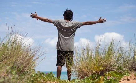 Indigenous man throws his hands wide