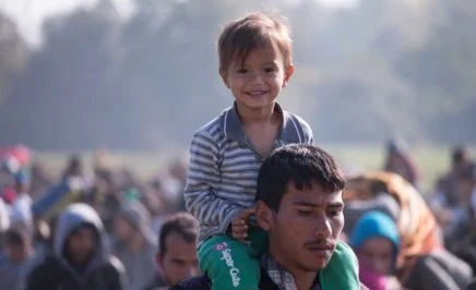 A boy on the shoulders of his father