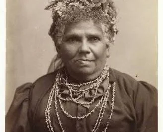 Sepia vintage photo of Fanny Cochrane Smith, Fanny Cochrane Smith wearing wattle in her hair and traditional shell necklace.