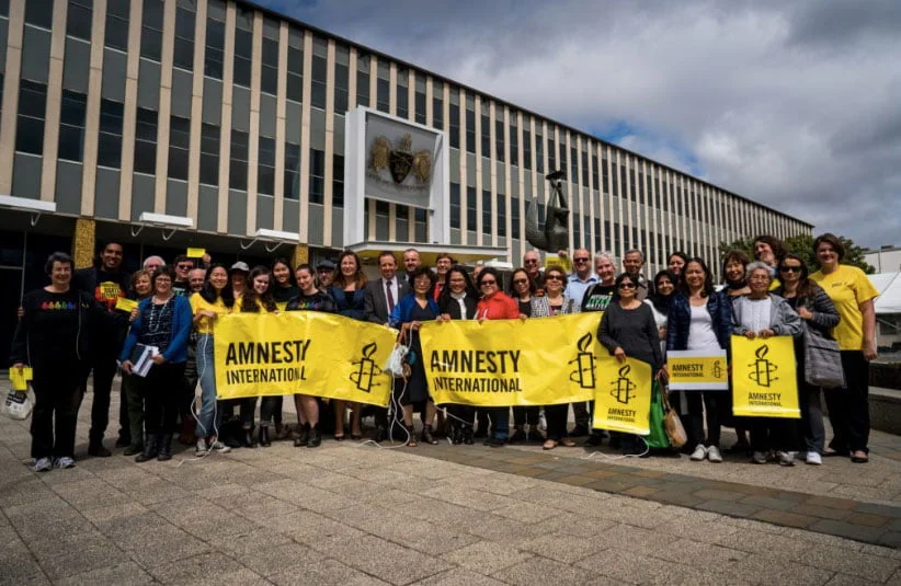 A group of people holding Amnesty banners