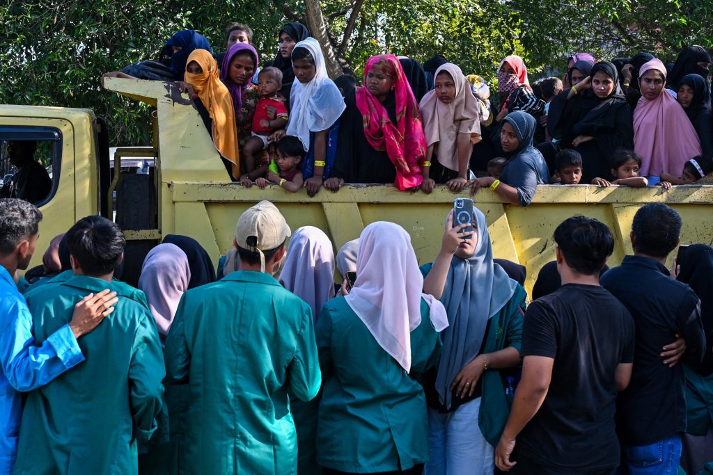 Rohingya refugees crowd into a vehicle for relocation to a nearby government building after demonstrating university students forced them out of the current government facility, in Banda Aceh on December 27, 2023. Hundreds of university students in Indonesia's westernmost province stormed a temporary shelter for more than a hundred Rohingya refugees on December 27, forcing them to leave in the latest rejection of the persecuted Myanmar minority. (Photo by CHAIDEER MAHYUDDIN / AFP)